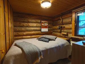 a bedroom with a bed in a log cabin at Holiday Hopsukka in Luosto
