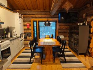 a kitchen with a wooden table and chairs at Holiday Hopsukka in Luosto
