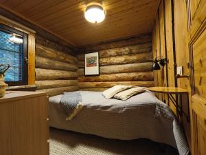 a bedroom with a bed in a log cabin at Holiday Hopsukka in Luosto +21 photos