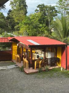 a small house with a red roof and yellow at Cabinas Hukats Secret Jungle in Puerto Viejo