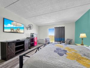 a bedroom with a bed and a flat screen tv at CRYSTAL PALACE RESORT in Bolivar Peninsula +79 photos