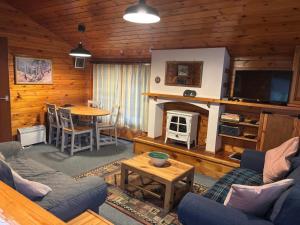 a living room with a couch and a tv and a table at 345 Ida's Cabin in Trawsfynydd +9 photos