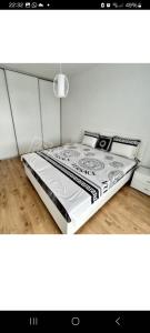 a bed with a black and white bed frame in a room at Apartment brand new in Seredʼ