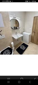 a bathroom with a sink and a toilet and a mirror at Apartment brand new in Seredʼ