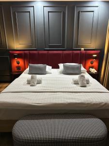 a large bed in a room with a red headboard at The Hotel National in Zagreb