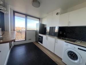 a kitchen with white cabinets and a washer at Appartement spacieux in Argenteuil +2 photos