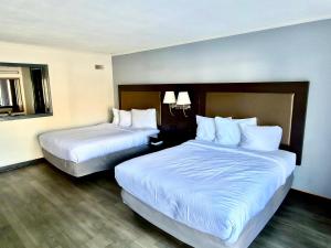 two beds in a hotel room with white pillows at Budget Inn Conway in Conway +7 photos