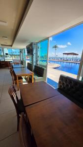 a dining room with tables and a view of the ocean at Apartamento em Arraial do Cabo in Arraial do Cabo
