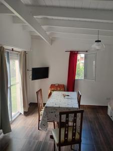 a dining room with a table and chairs at Departamentos Ruca Lauquén in Necochea +2 photos