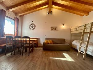 a living room with a couch and a table and a bed at Locanda B&B Da Nati in Arba
