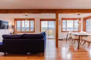 a living room with a couch and a table and chairs at Hôtel à la maison - La Bleue Maritime in Rivière-du-Loup