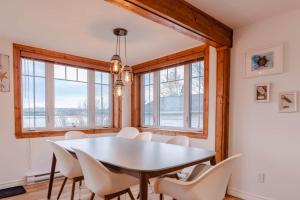 a dining room with a white table and chairs at Hôtel à la maison - La Bleue Maritime in Rivière-du-Loup