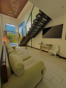 a living room with a couch and a staircase at The Madevelyn in Atitlán in Panajachel
