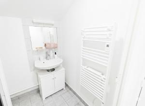 a white bathroom with a sink and a mirror at Studio spacieux avec bureau - Calme & Proche Lyon in Irigny