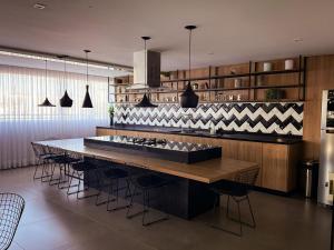 a kitchen with a large table and some chairs at Studio Prime Ribeirão Apogeo in Ribeirão Preto