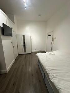 an empty room with a bed and two wardrobes at Spacious Flat White City in London +5 photos