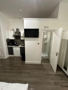 a room with a kitchen with a white door at Spacious Flat White City in London