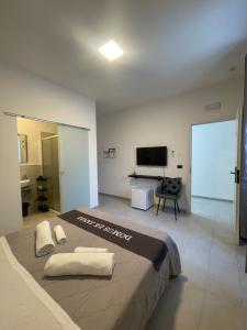 a bedroom with a large bed and a flat screen tv at Domus de janas 2 in Alghero