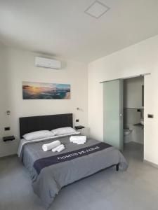 a bedroom with a bed with two towels on it at Domus de janas 2 in Alghero