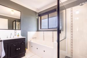 a bathroom with a tub and a sink and a shower at The Hideaway in Yeppoon +12 photos