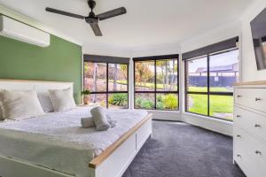 a bedroom with a large bed and windows at The Hideaway in Yeppoon