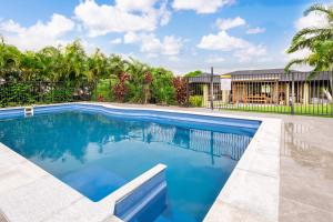 a swimming pool with blue water in a yard at The Hideaway in Yeppoon