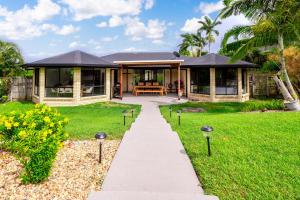 a house with a walkway in front of a yard at The Hideaway in Yeppoon