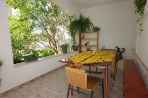 a dining room with a table and chairs and a window at Apartments Zoki in Vis