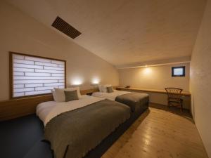 two beds in a room with a window at OTARU RETREAT KURAMURE by Onko Chishin in Otaru +106 photos