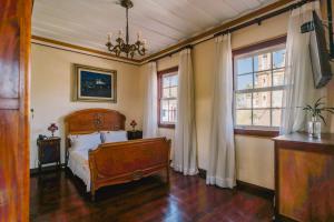 a bedroom with a bed and two windows at Teatro Hotel Boutique in Ouro Preto +117 photos