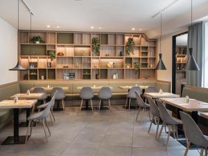 a restaurant with tables and chairs and shelves at ibis Styles Neckarsulm in Neckarsulm