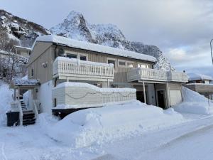 a house covered in snow in front of a mountain at Between fjord and mountain in Svolvær