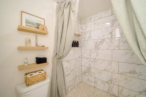 a bathroom with a shower and a toilet at Groups Welcome, Central Location! Tulsa Gem + Yard in Tulsa +23 photos