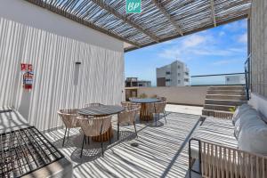 a patio with a table and chairs on a balcony at Makare Bucerias - Rooftop Pool and Steps to Beach in Bucerías