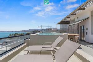 a balcony with a table and chairs and a swimming pool at Makare Bucerias - Rooftop Pool and Steps to Beach in Bucerías +29 photos