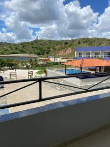 a balcony with a view of a pool and a building at Hotel e Restaurante Star New in Carmópolis