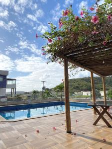 a table with flowers on it next to a swimming pool at Hotel e Restaurante Star New in Carmópolis +4 photos