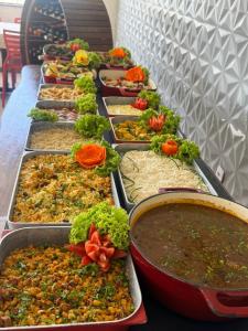 a row of trays filled with different types of food at Hotel e Restaurante Star New in Carmópolis