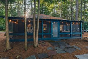 a blue house in the woods with trees at Camp Hudson Pines in Corinth