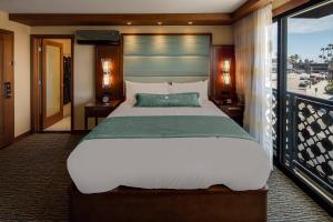 a bedroom with a large bed and a balcony at Cormorant Boutique Hotel in San Diego +40 photos