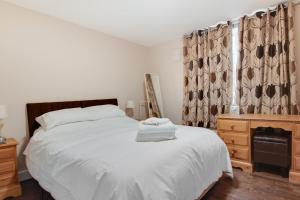 a bedroom with a white bed and a wooden dresser at 3 Bed in Great Waldingfield oc-ac2 in Waldingfield