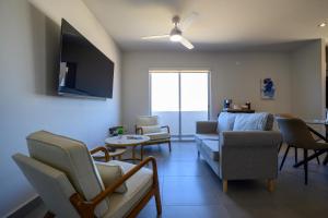 a living room with a couch and chairs and a table at Departamento La Paloma in Cabo San Lucas