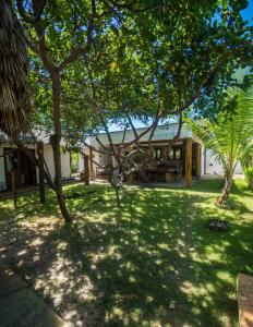 a house with a yard with trees in front of it at Atins - Vila Mani com piscina in Atins