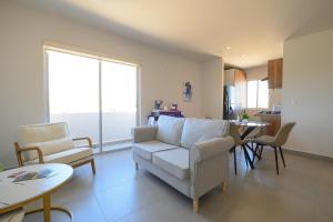 a living room with a couch and chairs and a table at Departamento La Paloma in Cabo San Lucas