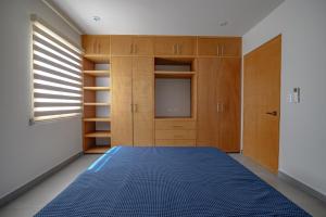 a bedroom with a blue bed and wooden cabinets at Departamento La Paloma in Cabo San Lucas