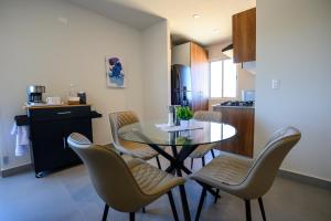 a dining room with a glass table and chairs at Departamento La Paloma in Cabo San Lucas +3 photos