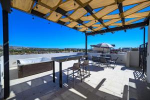 a patio with a table and chairs on a roof at Departamento La Paloma in Cabo San Lucas