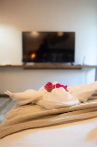 a towel with a flower on top of a bed at Atins - Vila Mani com piscina in Atins