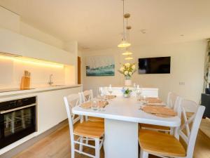 a white dining room table with white chairs and a kitchen at 1 Bed in Hythe oc-89966 in Hythe +7 photos