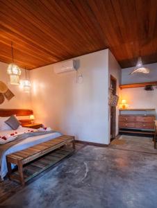 a bedroom with a bed and a wooden ceiling at Atins - Vila Mani com piscina in Atins +40 photos